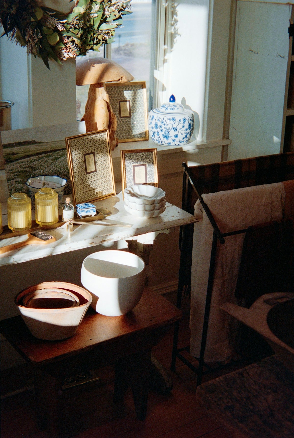 Sunlight streams across decorative bowls and jars on a shelf