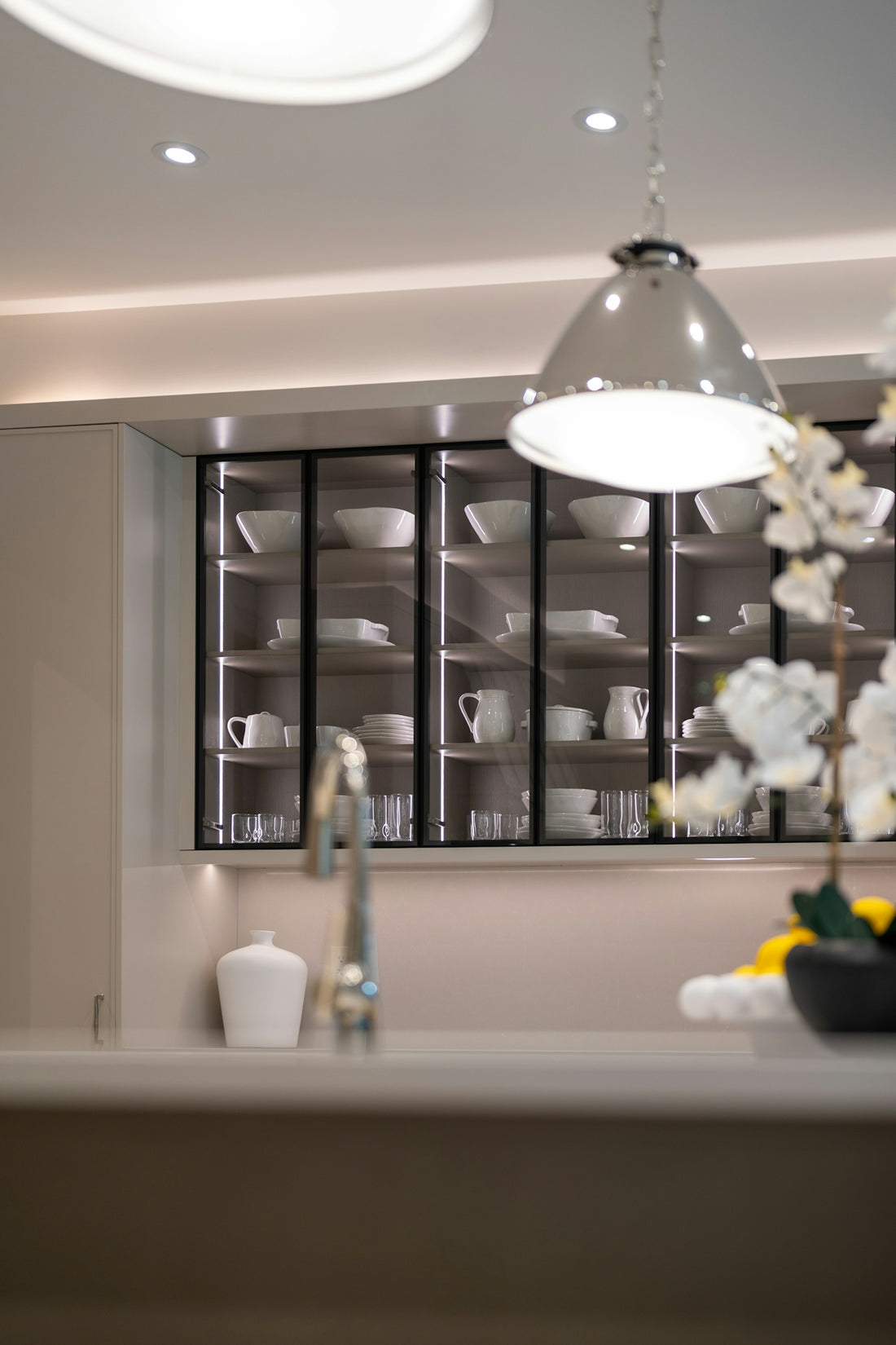 Modern kitchen with illuminated glass cabinets displaying dishes