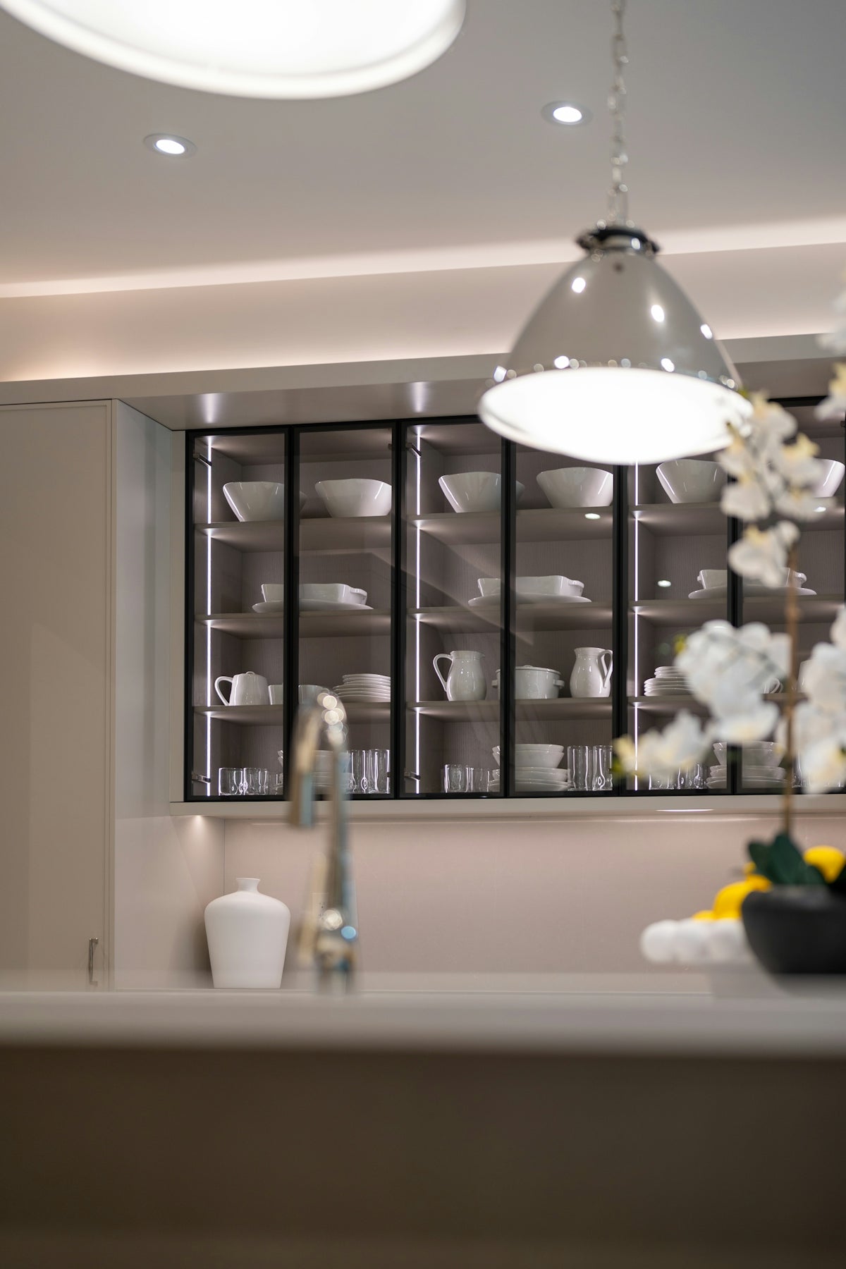 Modern kitchen with illuminated glass cabinets displaying dishes